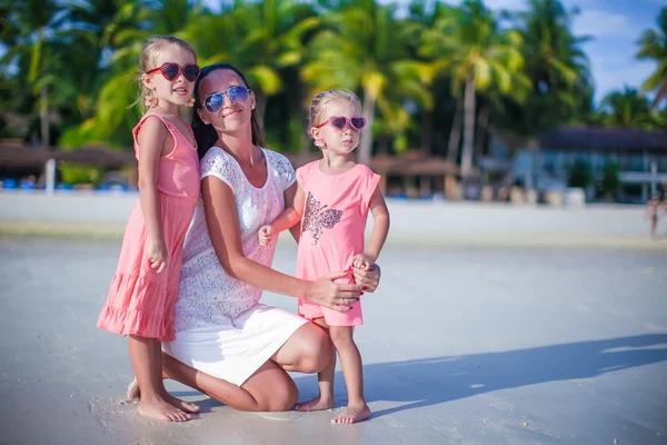 Mother and her cute little girls relaxing on exotic tropical beach — Stock Photo, Image