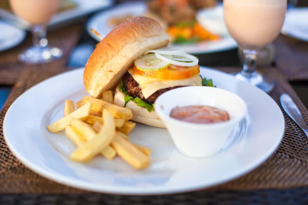 Hamburger e patatine fritte su piatto bianco a pranzo — Foto Stock