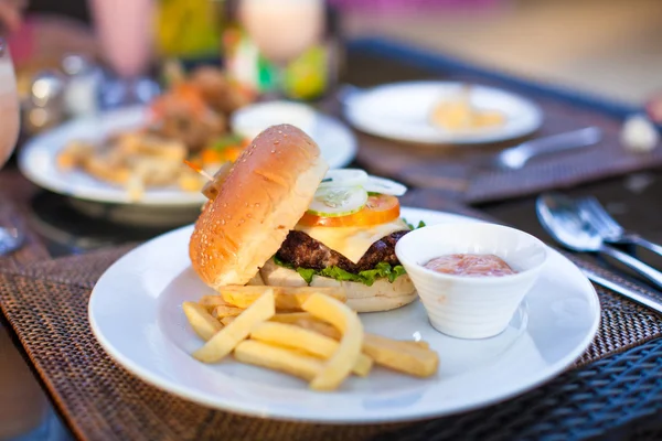 Hamburger e patatine fritte su piatto bianco a pranzo — Foto Stock