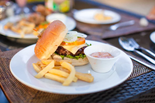 Hamburger e patatine fritte su piatto bianco a pranzo — Foto Stock