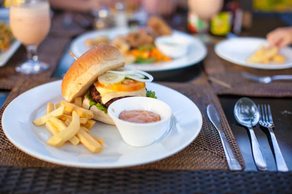 Hamburger e patatine fritte su piatto bianco a pranzo — Foto Stock