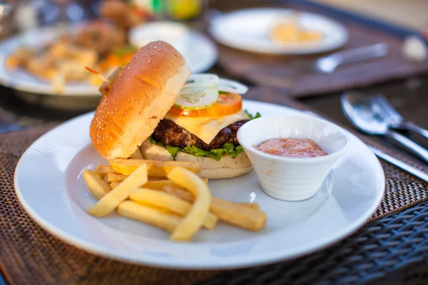 Hamburger e patatine fritte su piatto bianco a pranzo — Foto Stock