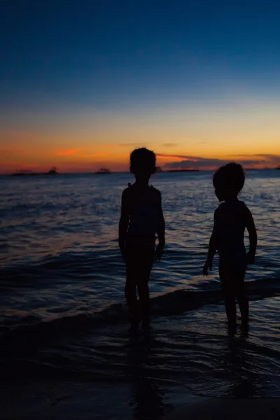 Silhouet van twee meisjes bij zonsondergang op het eiland boracay, Filippijnen — Stockfoto