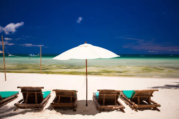 Göle bakan beyaz kum plajı üzerinde şemsiye ve şezlonglar — Stok fotoğraf