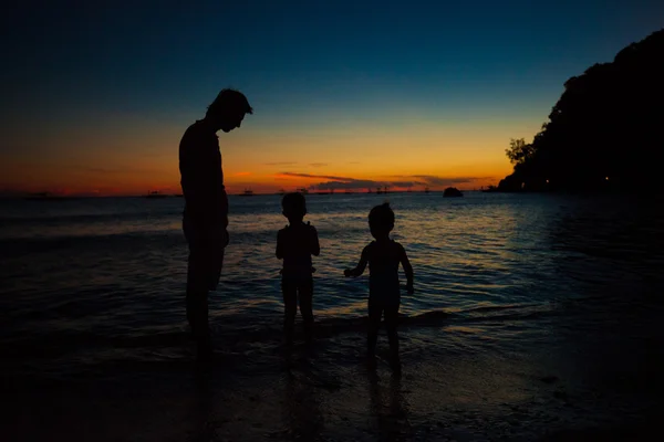 Father and daughters silhouettes in sunset at the beach on Boracay, Philippines — Stock Photo, Image