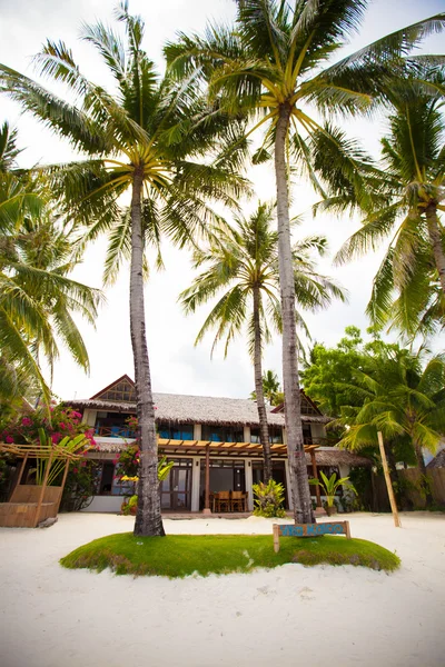 Hyggeligt lille hotel på et tropisk eksotisk resort på hvid sandstrand - Stock-foto