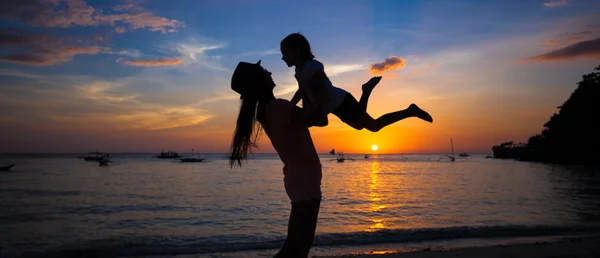 Kleines Mädchen und ihre Mutter amüsieren sich bei Sonnenuntergang auf der Insel Boracay, Philippinen — Stockfoto
