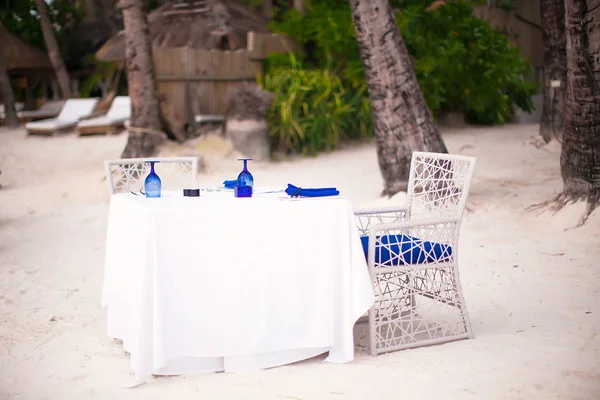 Empty open air table set for dinner on white beach — Stock Photo, Image