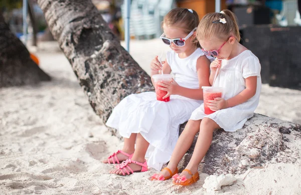 Adorable little girl drinking fresh watermelon on the beach — Stock Photo, Image