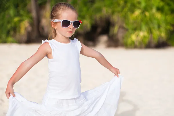 Portret beetje schattig meisje in het wit lange jurk op een tropisch strand — Stockfoto