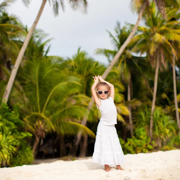 Kleines entzückendes Mädchen im weißen langen Kleid an einem tropischen Strand — Stockfoto