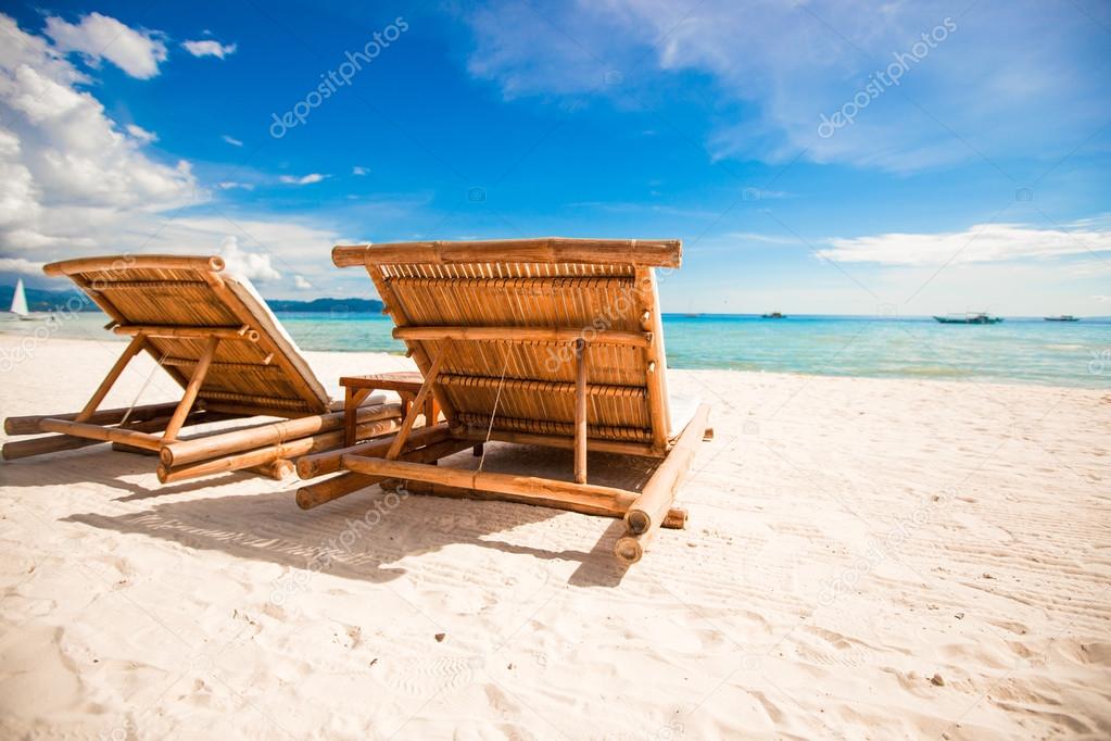 Paradise view of nice tropical empty sandy plage with umbrella and beach chair
