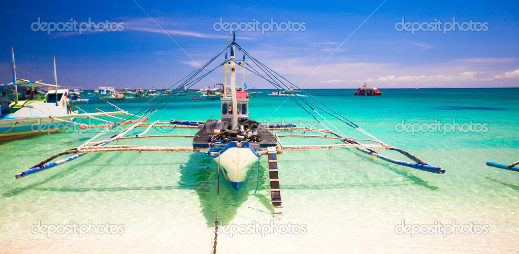 Boat at the white beach with turquoise water in Boracay, Philippines