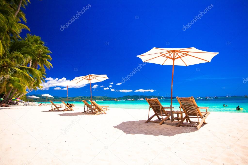 Paradise view of nice tropical empty sandy plage with umbrella and beach chair