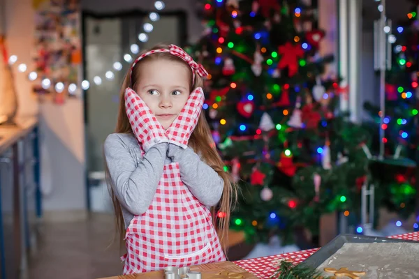 Gelukkig meisje in droeg wanten bakken Kerstmis peperkoek cookies — Stockfoto