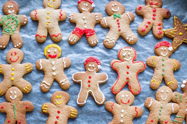 Raw gingerbread men with glaze on a baking sheet — Stock Photo, Image