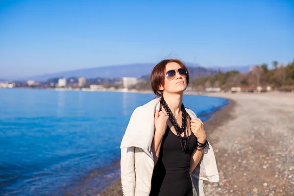 Beautiful young woman relax on the beach in winter sunny day alone — Stock Photo, Image