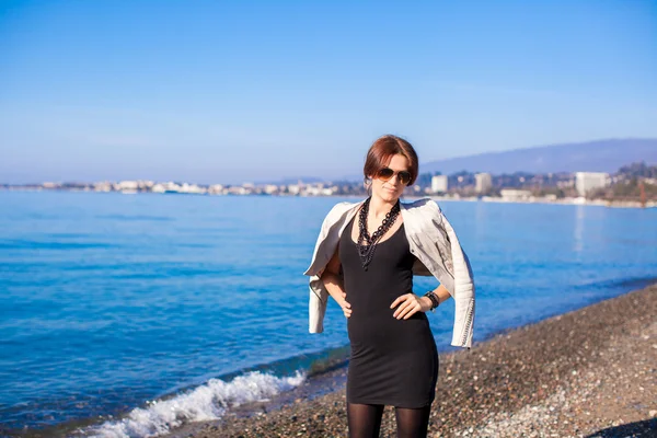 Portrait of Beautiful young woman walking on the beach in winter sunny day alone — Stock Photo, Image