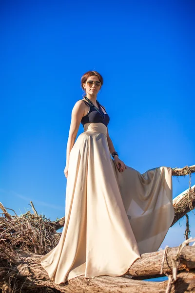 Charming young woman in a long dress posing on the beach — Stock Photo, Image