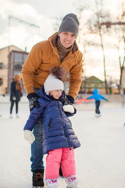 Młody tata uczy córkę mały skate na lodowisko — Zdjęcie stockowe