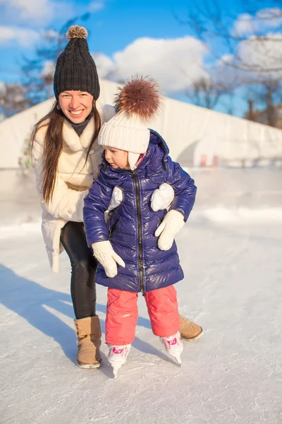 Feliz niña emocionada y su joven madre aprendiendo patinaje sobre hielo —  Fotos de Stock