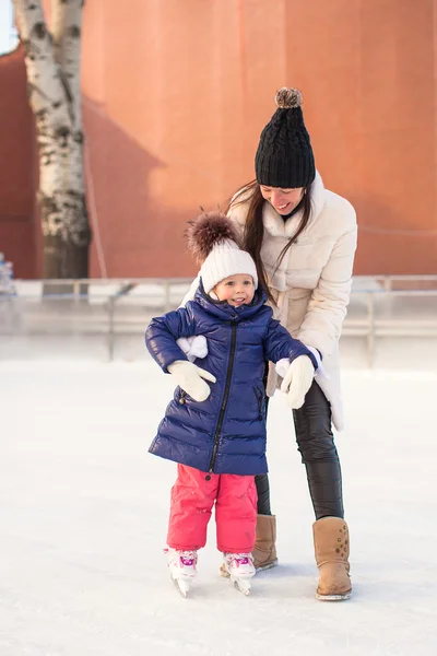 Happy excited little girl and her young mother learning ice-skating — Stock Photo, Image