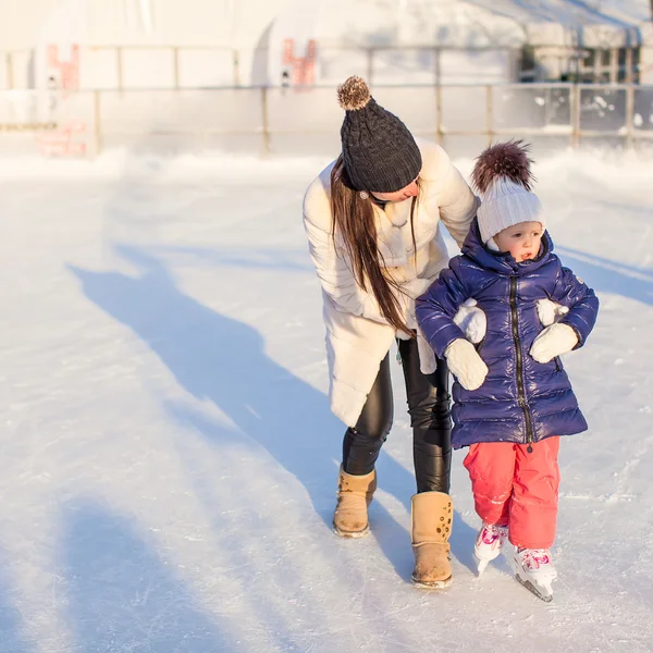 Heureuse petite fille excitée et sa jeune mère apprenant le patinage sur glace — Photo