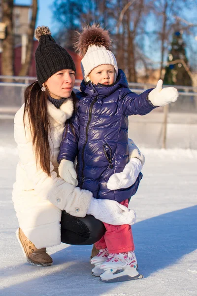 Jeune mère et sa jolie petite fille sur une patinoire — Photo