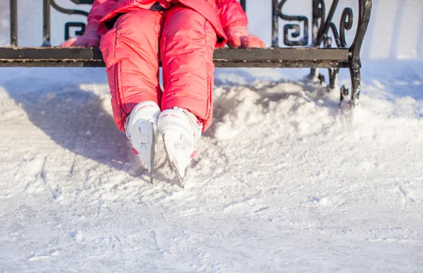 Primer plano de las piernas del pequeño patinador de pie en la pista de hielo de invierno —  Fotos de Stock