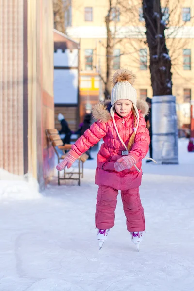 Entzückend glückliches kleines Mädchen genießt Schlittschuhlaufen auf der Eisbahn — Stockfoto