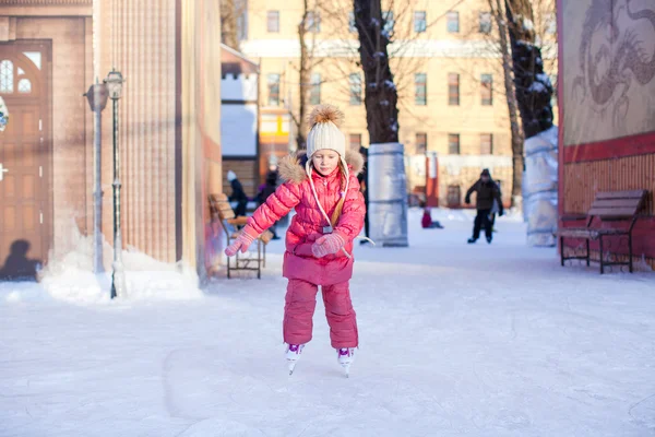 Adorable happy little girl enjoying skating at the ice-rink — Stock Photo, Image