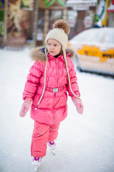 Adorable niña feliz disfrutando patinando en la pista de hielo —  Fotos de Stock