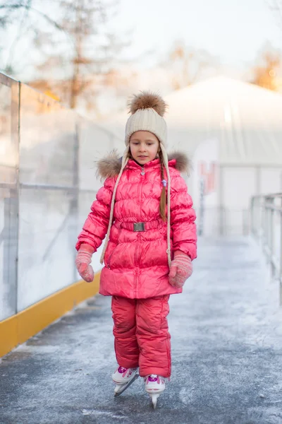 Adorable niña feliz disfrutando patinando en la pista de hielo —  Fotos de Stock
