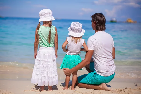 Adorable little girls and young father on tropical white beach — Stock Photo, Image