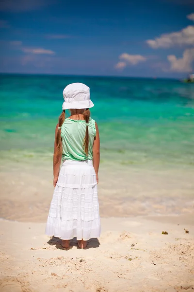 Rückansicht eines kleinen Mädchens mit Hut am weißen Sandstrand mit Blick aufs Meer — Stockfoto