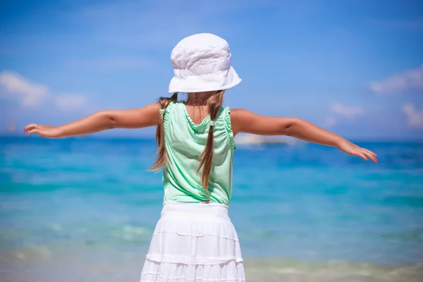 Vista posterior de la hermosa niña extendió sus brazos en una playa exótica — Foto de Stock