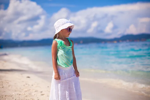 Очаровательная улыбающаяся маленькая девочка в тропическом отпуске на белом песчаном пляже — стоковое фото