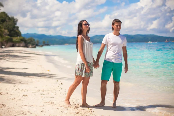 Jovem casal caminhando na praia de areia perto do mar — Fotografia de Stock