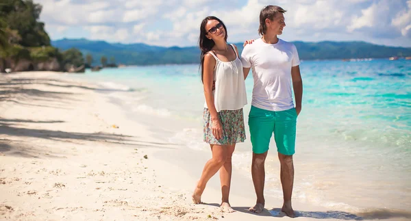 Pareja joven caminando en la playa de arena cerca del mar —  Fotos de Stock