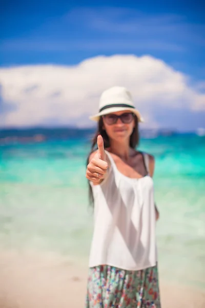 Junge entzückende Frau zeigt Daumen nach oben am weißen Strand — Stockfoto