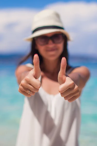 Молодая очаровательная женщина показывает большие пальцы на белом пляже — стоковое фото