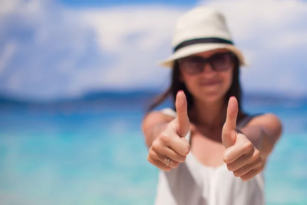 Молодая красивая женщина показывает большие пальцы на пляже — стоковое фото