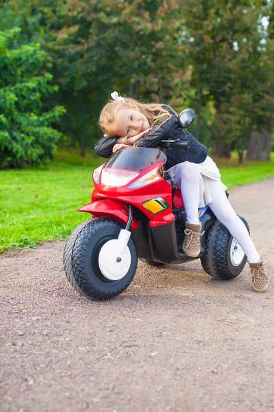 Lilla bedårande tjej att ha kul på sin cykel i grön park — Stockfoto