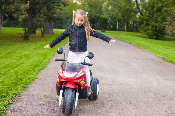 Little beautiful rock girl in leather jacket on her bike — Stock Photo, Image