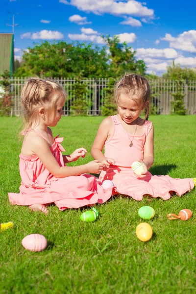 Adorable little girls having fun with Easter Eggs on green grass — Stock Photo, Image