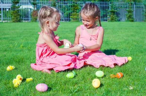 Adoráveis meninas brincando com ovos de Páscoa na grama verde — Fotografia de Stock