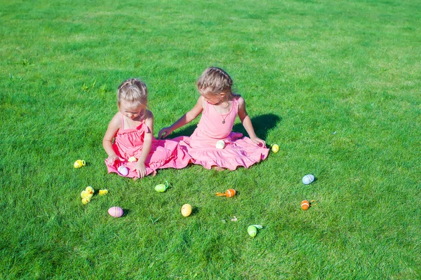 Yeşil çimenlerin üzerinde Paskalya yumurtaları ile oynarken sevimli küçük kızlar — Stok fotoğraf