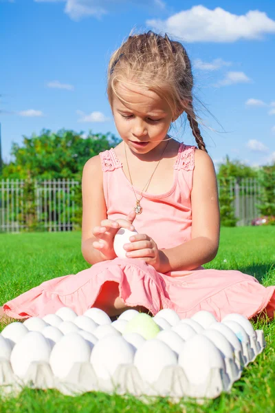 Portret van schattig meisje spelen met witte Pasen eieren op groen gras — Stockfoto