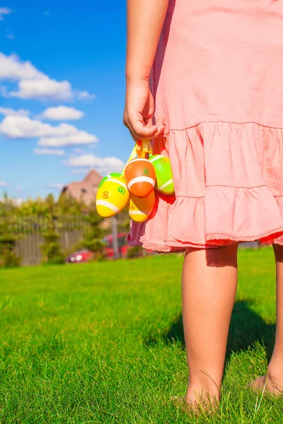 Gros plan coloré oeufs de Pâques dans les mains de petite fille mignonne — Photo