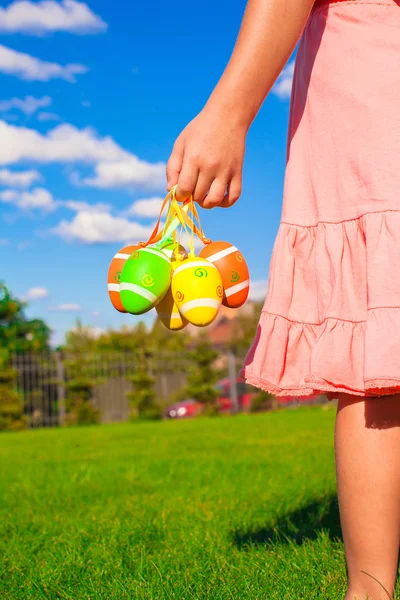 Gros plan main d'une petite fille tenant des œufs de Pâques colorés — Photo